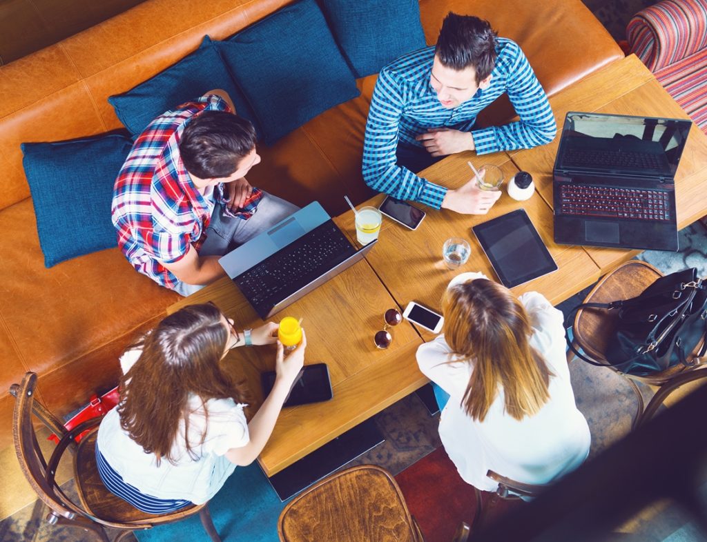 Photo of people with laptops around a table