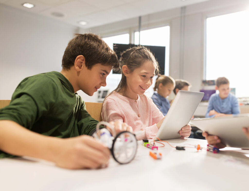 Photo showing two children using a laptop during class