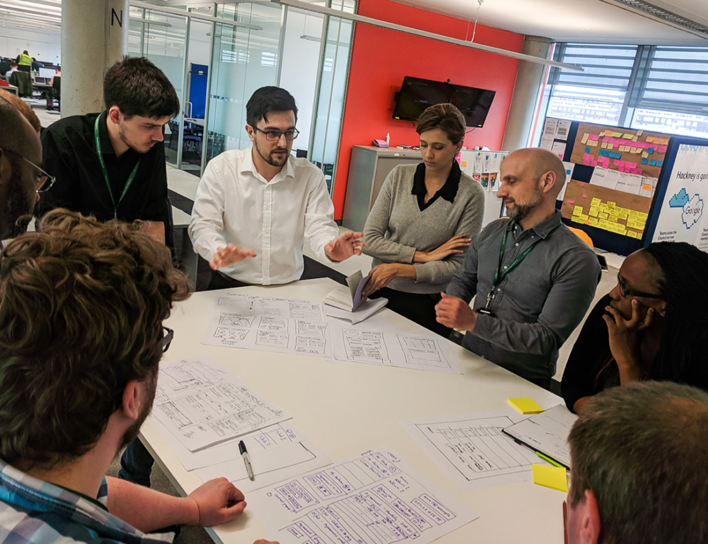 Photo showing a group of people surrounding a table