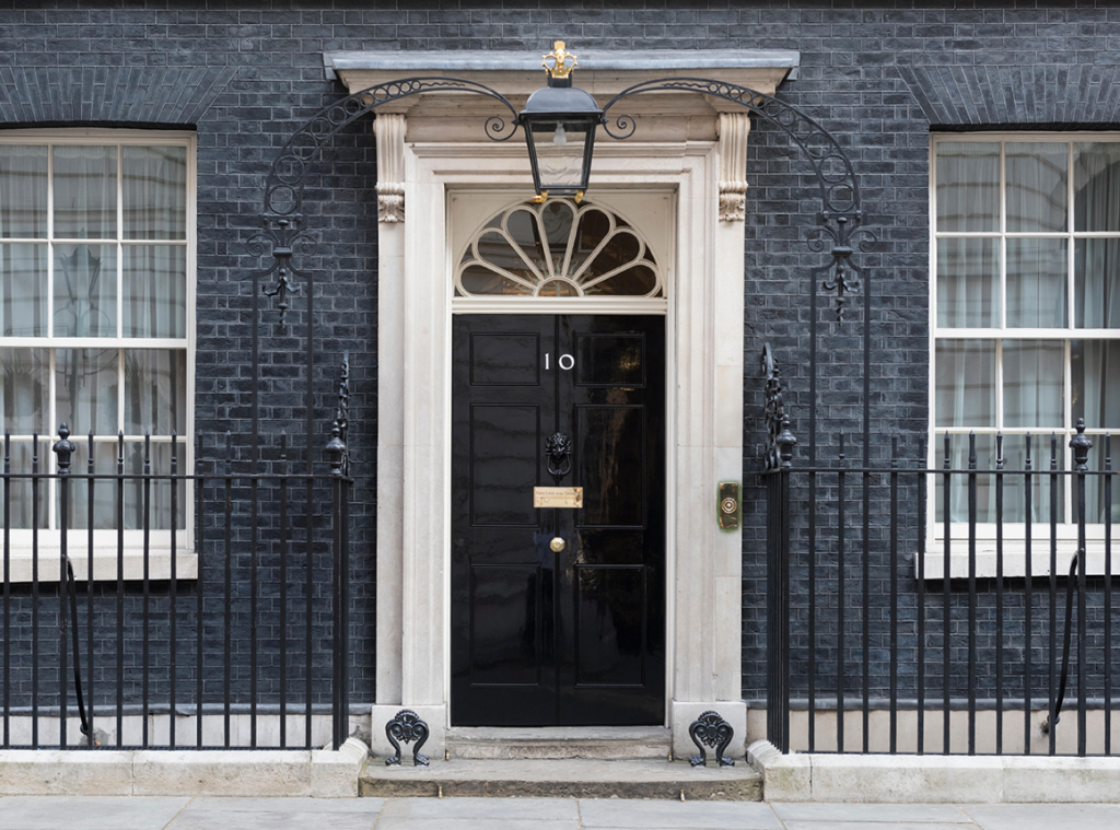 Image of black door with number 10 on the front of grey brick building