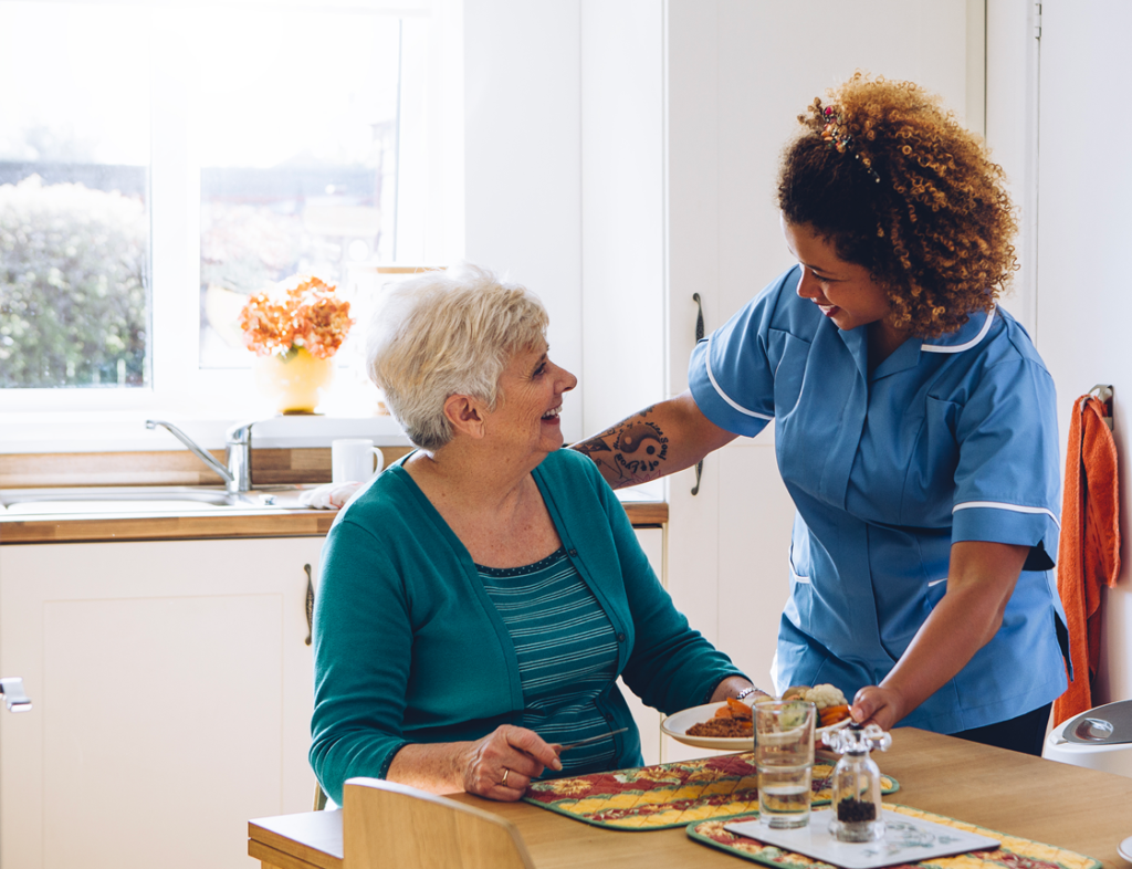 Photo showing a nurse speaking elderly patient smiling