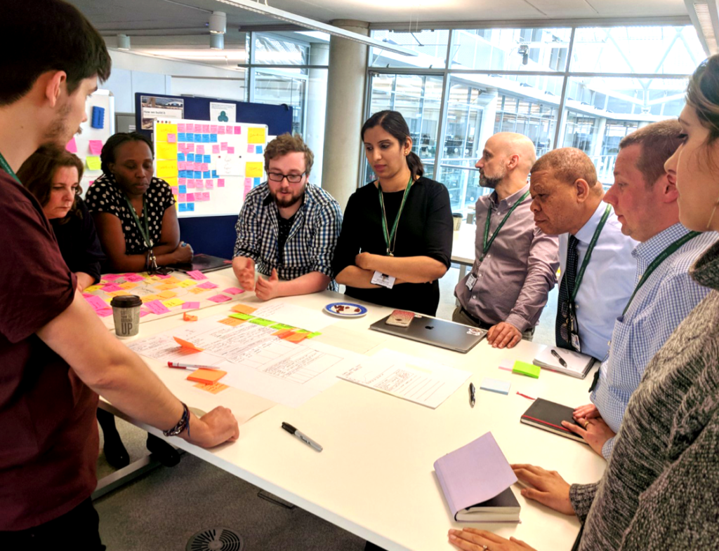 Photo showing the Made Tech team at a meeting around a table