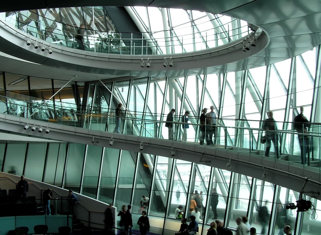 People walking down stairs in glass building