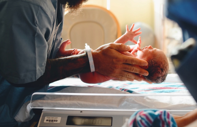 Photo of newborn baby being held by nurse