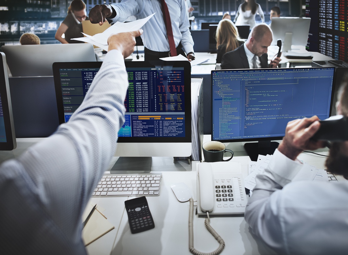 Photo showing people working in a busy security office