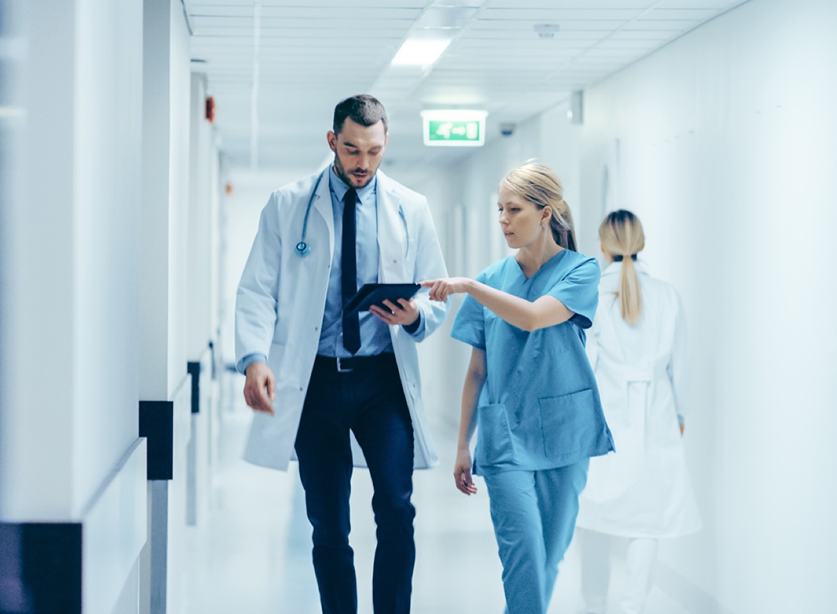 Photo showing Doctor and Nurse walking together looking at an iPad