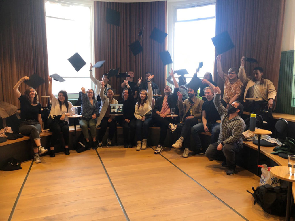 Photo showing previous Made Tech academy graduates throwing their mortarboards into the air