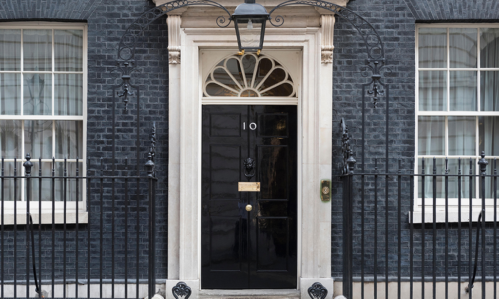 Image of black door with number 10 on the front of grey brick building
