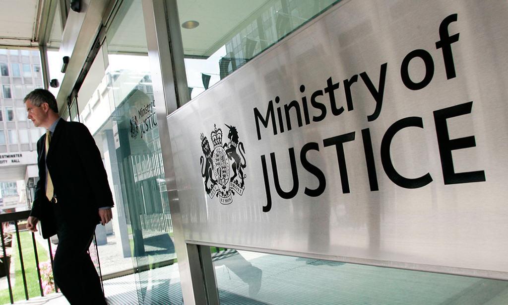Image of man leaving glass building with a sign that says Ministry of Justice