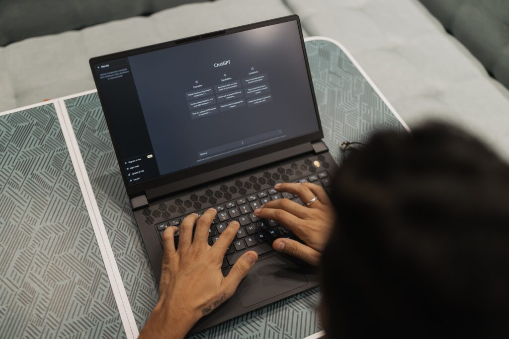 Top-down view of someone at a laptop computer with the ChatGPT main interface on the screen.