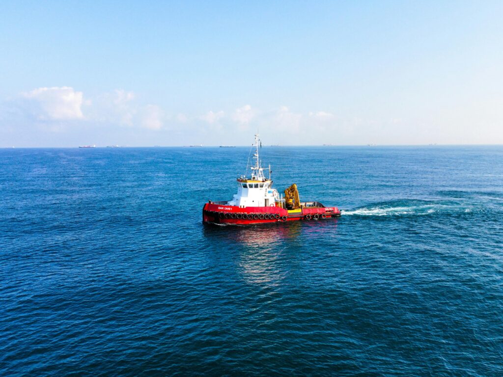 A red tugboat can be seen at sea