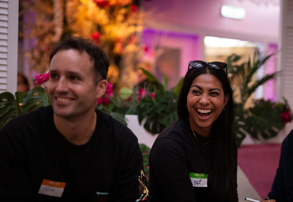two colleagues sitting side by side laughing
